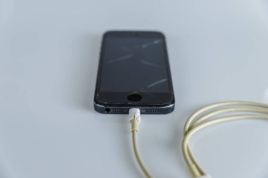 Bozuk şarj aleti akıllı telefonu beyaz arkaplanda izole edildi.