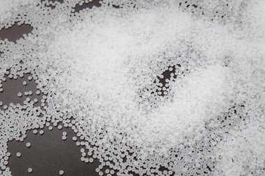 Ahşap arka planda beyaz plastik boncuklar polimer reçine, polimer palet petrokimyasal fabrikalardan alınmış ürünler. granüller polimer,
