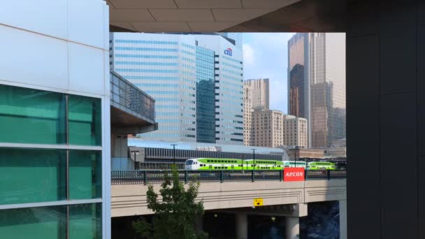 Toronto Go Train arriveert op een perron bij Union station terminal tijdens het passeren van CN Tower en stedelijke skyline gebouwen — Stockvideo