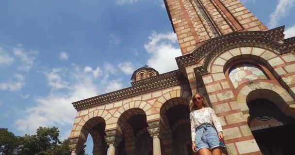 Joven mujer atractiva frente a la iglesia de San Marcos, Belgrado Serbia en el verano — Vídeo de stock