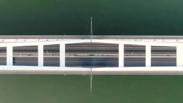 Vista aérea de arriba hacia abajo de Birdseye del tráfico vial en el puente moderno sobre el río verde — Vídeos de Stock