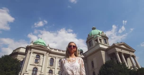 Belgrado, Servië. Jonge vrouw loopt voor de Nationale Assemply Parlement — Stockvideo