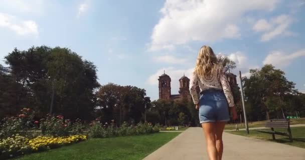 Siguiendo a una joven caminando en el Parque Tasmajdan en Belgrado, Serbia — Vídeos de Stock