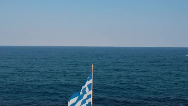 Vista aérea, revelación del ondulamiento de la bandera griega en el viento por Blue Sea Landscape, Grecia — Vídeos de Stock