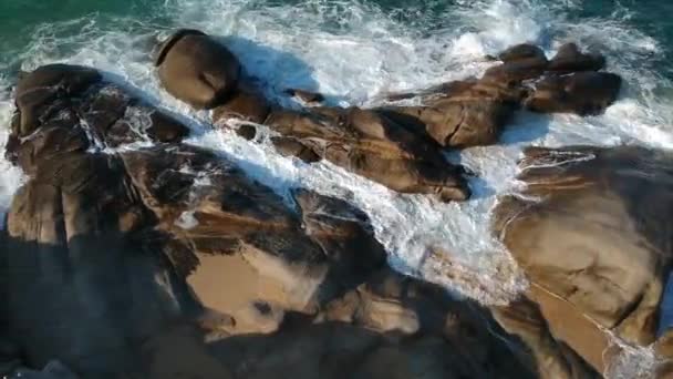 Літаючі стежки над гладкими океанськими скелями з ніжними кричущими хвилями, вигляд повітря — стокове відео