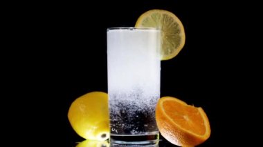 Limonlu ve portakallı soda. Siyah Arkaplanda İçecek Tazeleniyor