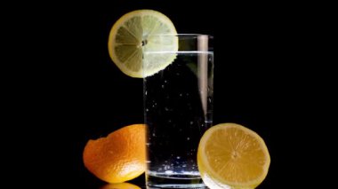 Limonlu Soda ve Dilimlenmiş Portakal Siyah Arkaplanda Döner
