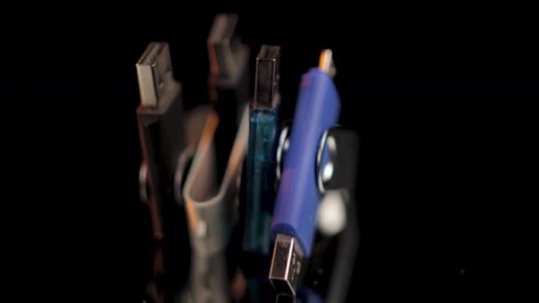 Cuatro unidades flash USB giran sobre fondo negro aislado, de cerca — Vídeos de Stock