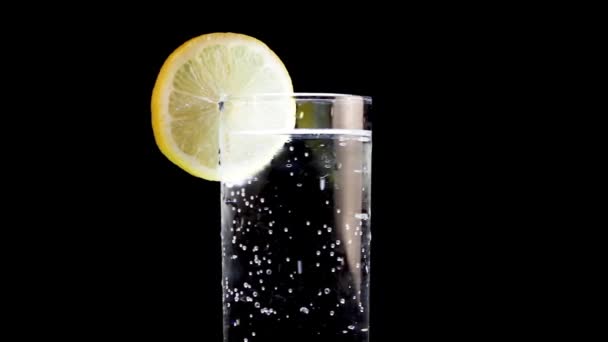 Close Up of Glass of Sparkling Soda Water With a Lemon Wedge, černé pozadí — Stock video