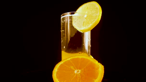 Refrescante saudável bebida de verão, água com limão em fundo preto, close-up — Vídeo de Stock