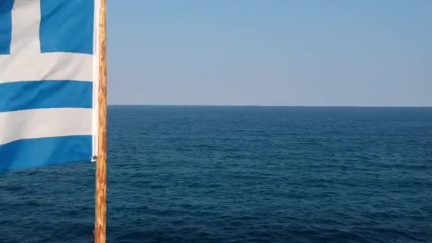 Воздушный вид на греческий национальный флаг, машущий перед морем и горизонтом, беспилотник — стоковое видео