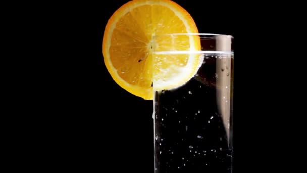 Glas parkeerwater met citroenschijfje erop. Verfrissend drankje, close up — Stockvideo