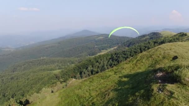 Парапланеризм, вид с воздуха. Летняя деятельность и зеленый горный ландшафт — стоковое видео