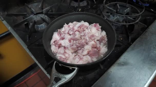 Κοντινό πλάνο του ακατέργαστου τεμαχισμένου κρέατος τηγανίσματος σε καυτό λάδι στην κουζίνα, αργή κίνηση — Αρχείο Βίντεο