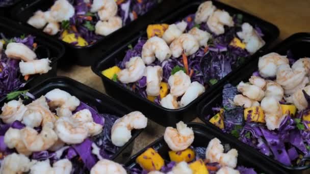 Crevettes avec salade multivitaminée et croûtons d'ail dans des boîtes de nourriture de livraison noires — Video