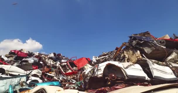 Купка зруйнованих автомобілів у великому смітті на сонячний день на об'єкті переробки — стокове відео