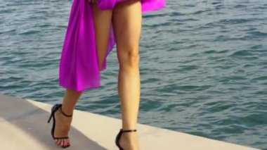 Mor Elbiseli Genç Seksi Kadın ve Yüksek Topuklular Miami 'de Deniz kenarında Yürüyor