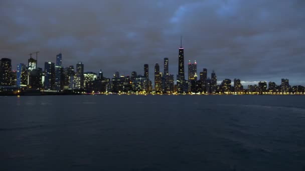 Драматическое ночное небо над центром Чикаго и огни озера Мичиган на набережной — стоковое видео