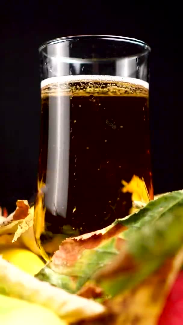 Vídeo vertical, vaso de cerveza ligera en la decoración de otoño, marco completo — Vídeos de Stock