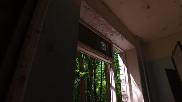 Escuela abandonada en Pripyat, Chernobyl, Ucrania. Ventana rota y árboles — Vídeo de stock