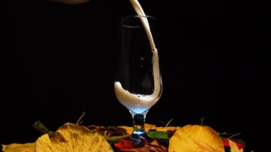 Sonbahar yapraklı bardağa taze süt dökmek, stüdyo çekimi.