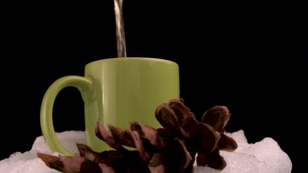 Versare il tè caldo in tazza nella neve con le pigne, Close Up Spin Full Frame — Video Stock
