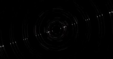 Çelik bir gölgede kesilmiş çizgilerden oluşan parlayan daireler saat yönünde döner. Yüzeylerinde, bir ışık demeti saat yönünün tersine döner..