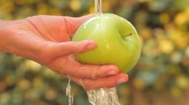 Yeşil elma el altında akan su ağır çekim