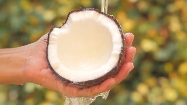 Kokosnuss in der Hand unter fließendem Wasser Zeitlupe — Stockvideo