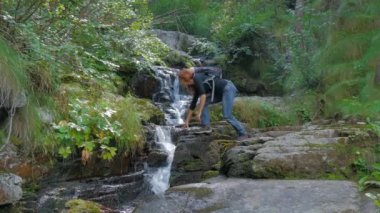 uzun yürüyüşe çıkan kimse kadın içme suyu vahşi bir ormanın içinde bir sel