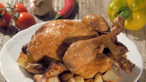 Roast chicken with baked potatoes on white plate rotating — Stock Video