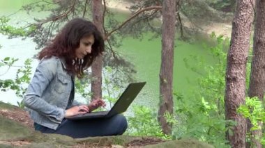 Onu laptop yeşil bir göl yakınında olan kadın