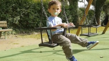 Young Boy Playing On A Swing