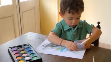 evde suluboya ile eğlenen çocuk