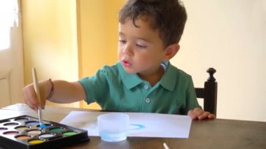 evde suluboya ile eğlenen çocuk