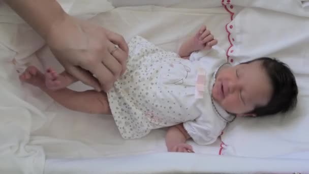 En nyfödd baby flicka och hennes mammas hand — Stockvideo