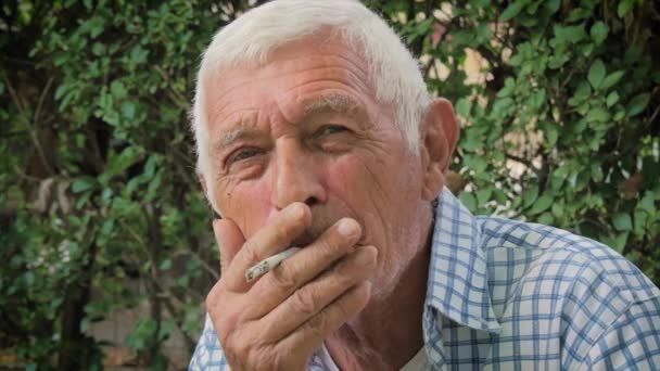 A senior man smoking a cigarette — Stock Video