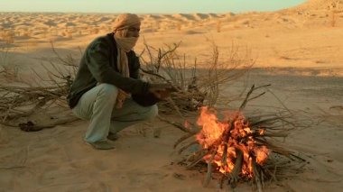 Sahara adamın yanına bir yangın.