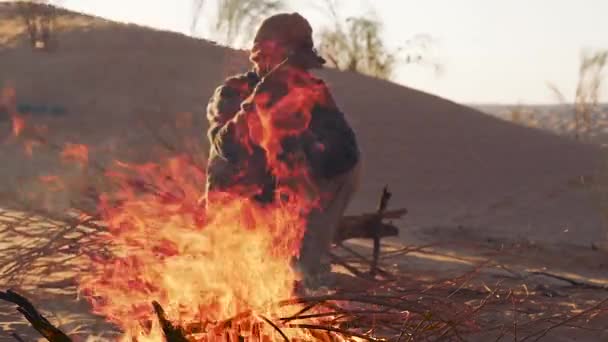 Sahara man in de buurt van een brand. — Stockvideo