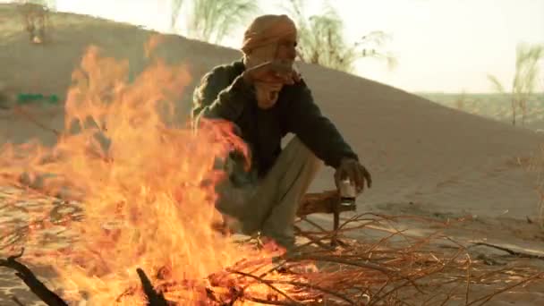 Sahara man drinking coffee near a fire. — Stock Video