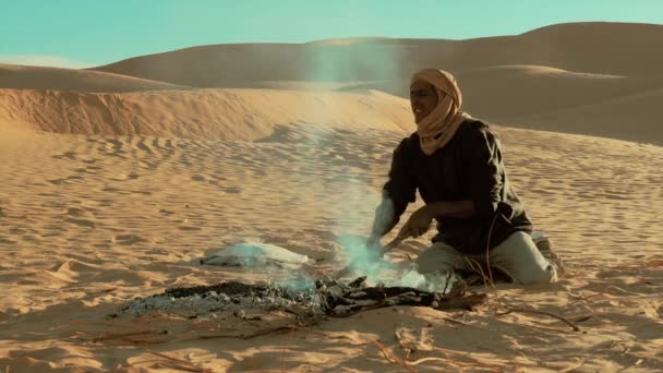 Sahara man förbereda glödande kol för bröd. — Stockvideo