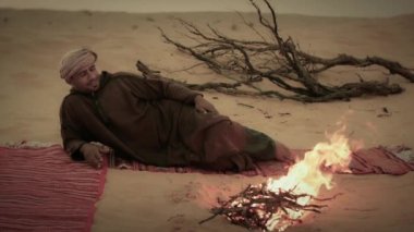 Ses de dahil olmak üzere bir ateşin yanında şarkı Sahara adam.