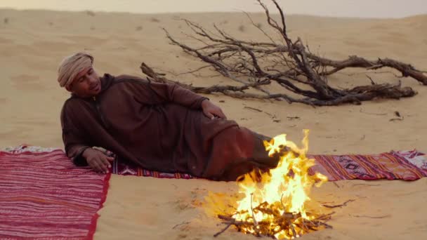 Sahara man in de buurt van een brand. — Stockvideo