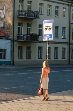 Otobüs bekleyen bir kadın.