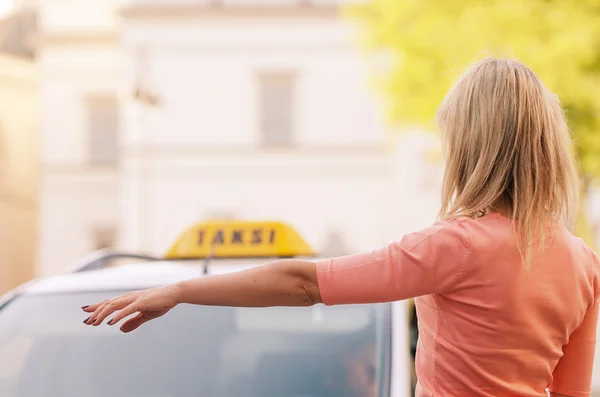 Mujer llamando a un taxi Fotos de stock libres de derechos