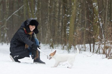 Genç bayan köpekle oynuyor.