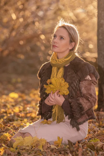 Mooie vrouw met herfstbladeren — Stockfoto