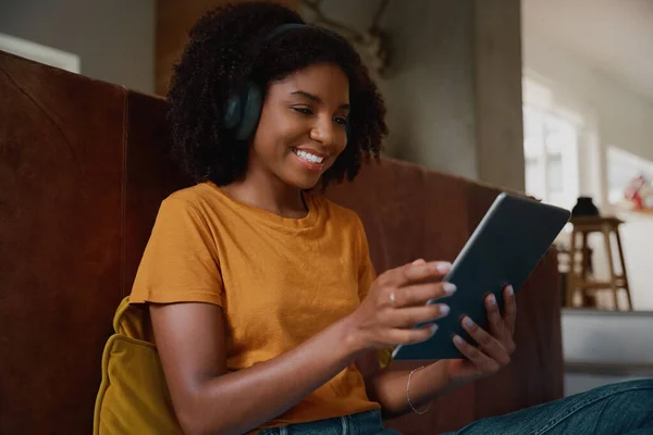 Jeune femme africaine se détendre à la maison en regardant la vidéo sur tablette numérique à la maison — Photo