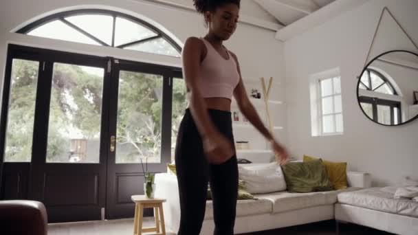 Молодая спортивная африканская женщина делает утренние упражнения стоя в современной гостиной — стоковое видео