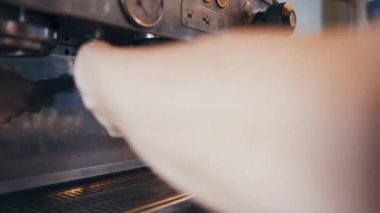 Profesyonel espresso makinesi seramik fincana sert bir kahve dolduruyor.